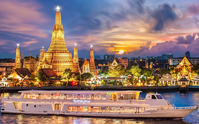 Chao Phraya Princess cruise passing Wat Arun at sunset during New Year's Eve in Bangkok.