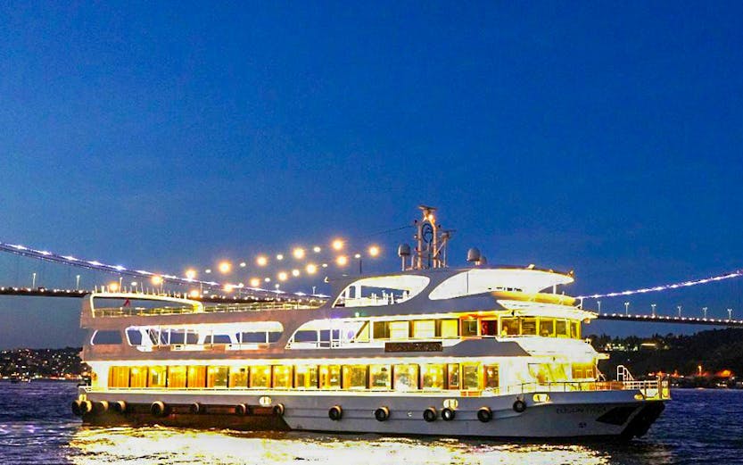 Cruise ship on Bosphorus at night with bridge lights, Istanbul.