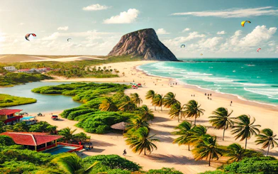 Beach with palm trees and Pedra Furada rock formation in Jericoacoara, Brazil, with kite surfers in the sky.