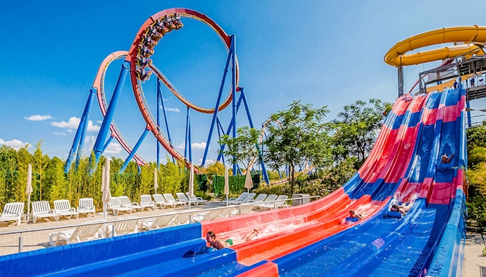 Parque Warner roller coaster with vibrant characters and visitors enjoying the ride.