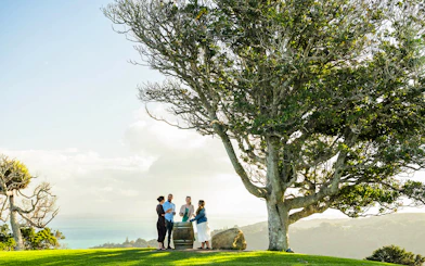 Friends enjoying wine at Batch Winery, Waiheke Island, with ocean view.