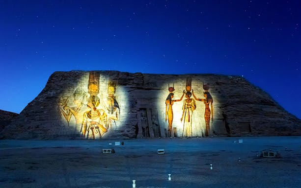 Abu Simbel temple illuminated at night, Aswan, Egypt, showcasing ancient carvings.