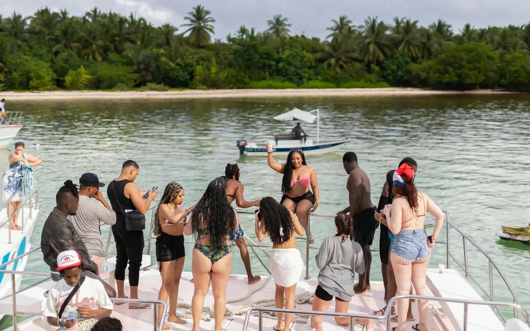 Group enjoying a boat party near Punta Cana with lush greenery in the background.