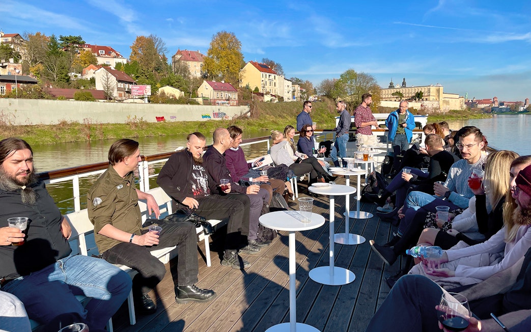 People enjoying a Vistula River sightseeing cruise in Krakow, Poland, with cityscape views.