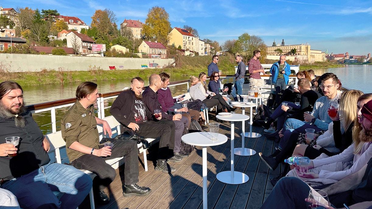 People enjoying a Vistula River sightseeing cruise in Krakow, Poland, with cityscape views.