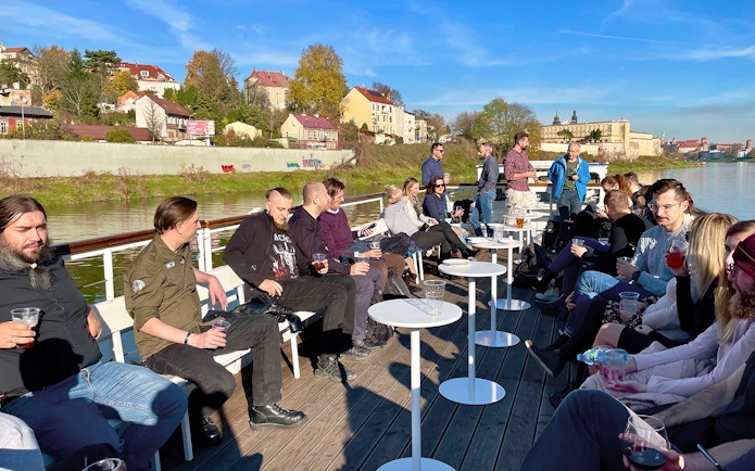 People enjoying a Vistula River sightseeing cruise in Krakow, Poland, with cityscape views.