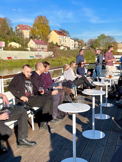 People enjoying a Vistula River sightseeing cruise in Krakow, Poland, with cityscape views.