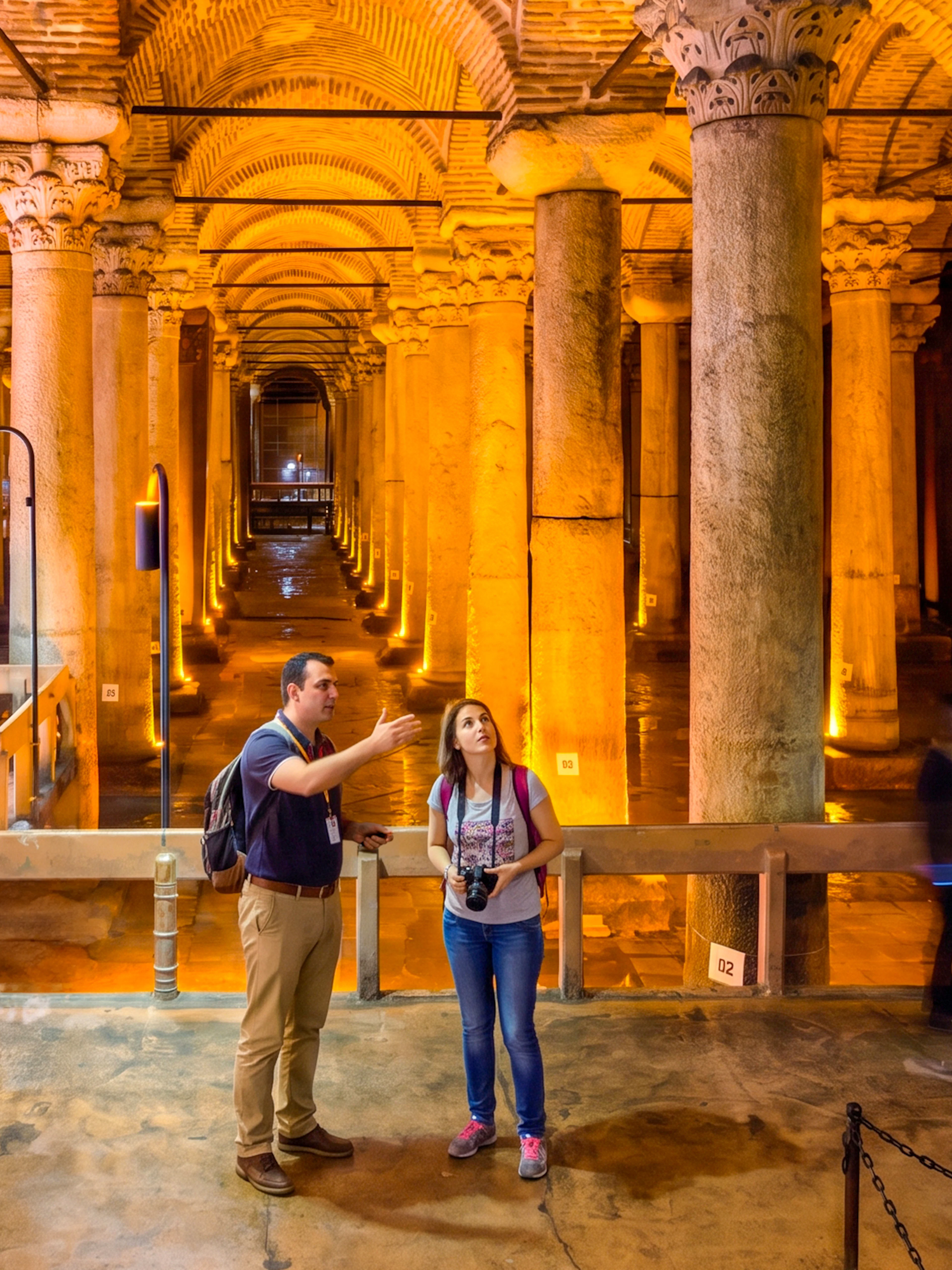 Visitors exploring the Basilica Cistern's illuminated columns in Istanbul.