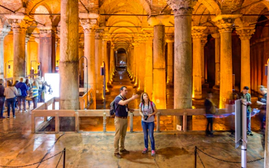 Visitors exploring the Basilica Cistern's illuminated columns in Istanbul.
