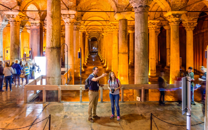 Visitors exploring the Basilica Cistern's illuminated columns in Istanbul.