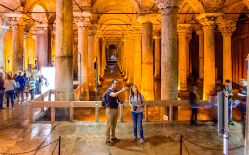 Visitors exploring the Basilica Cistern's illuminated columns in Istanbul.