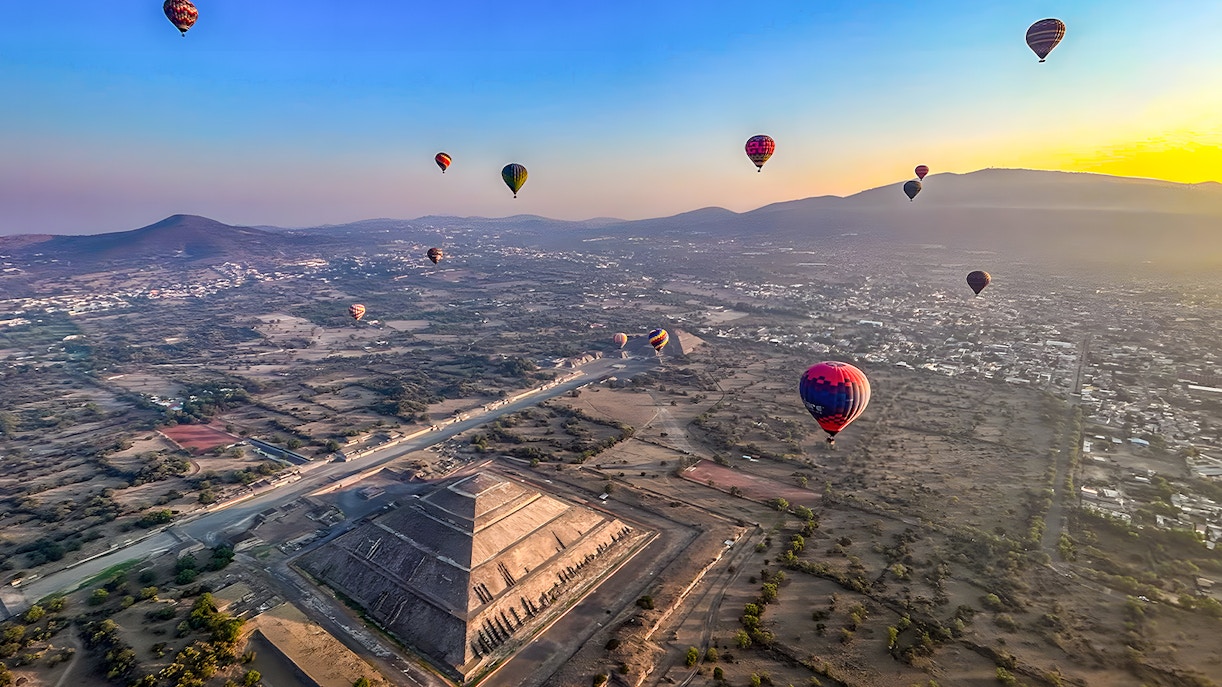 Hot air balloons floating over the Pyramid of the Sun in Teotihuacan, Mexico.