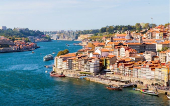 Porto riverside view with colorful buildings and boats on the Douro River, Portugal.