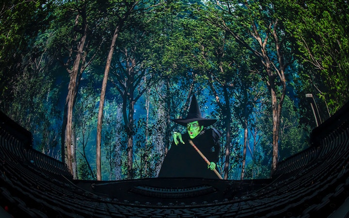 Wicked Witch scene from Wizard of Oz show at Sphere, surrounded by forest backdrop.