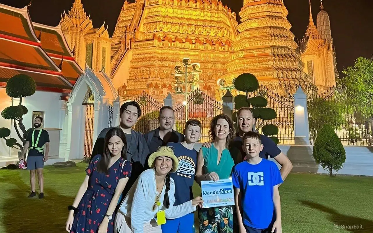 Group in front of illuminated temple during Bangkok Tuk Tuk tour.