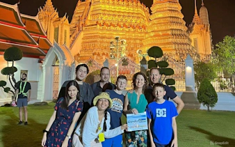 Group in front of illuminated temple during Bangkok Tuk Tuk tour.