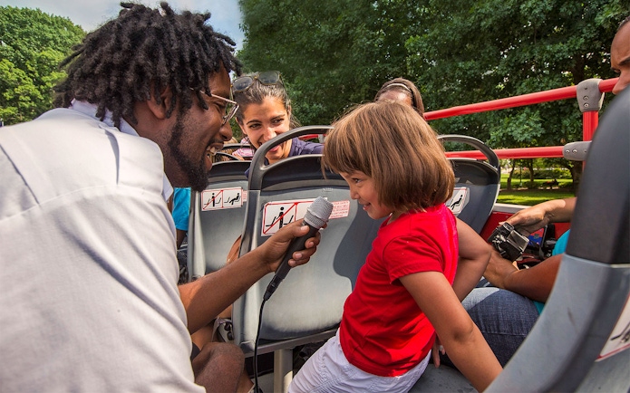Tour guide interacting with a child on a Los Angeles hop-on hop-off bus tour.