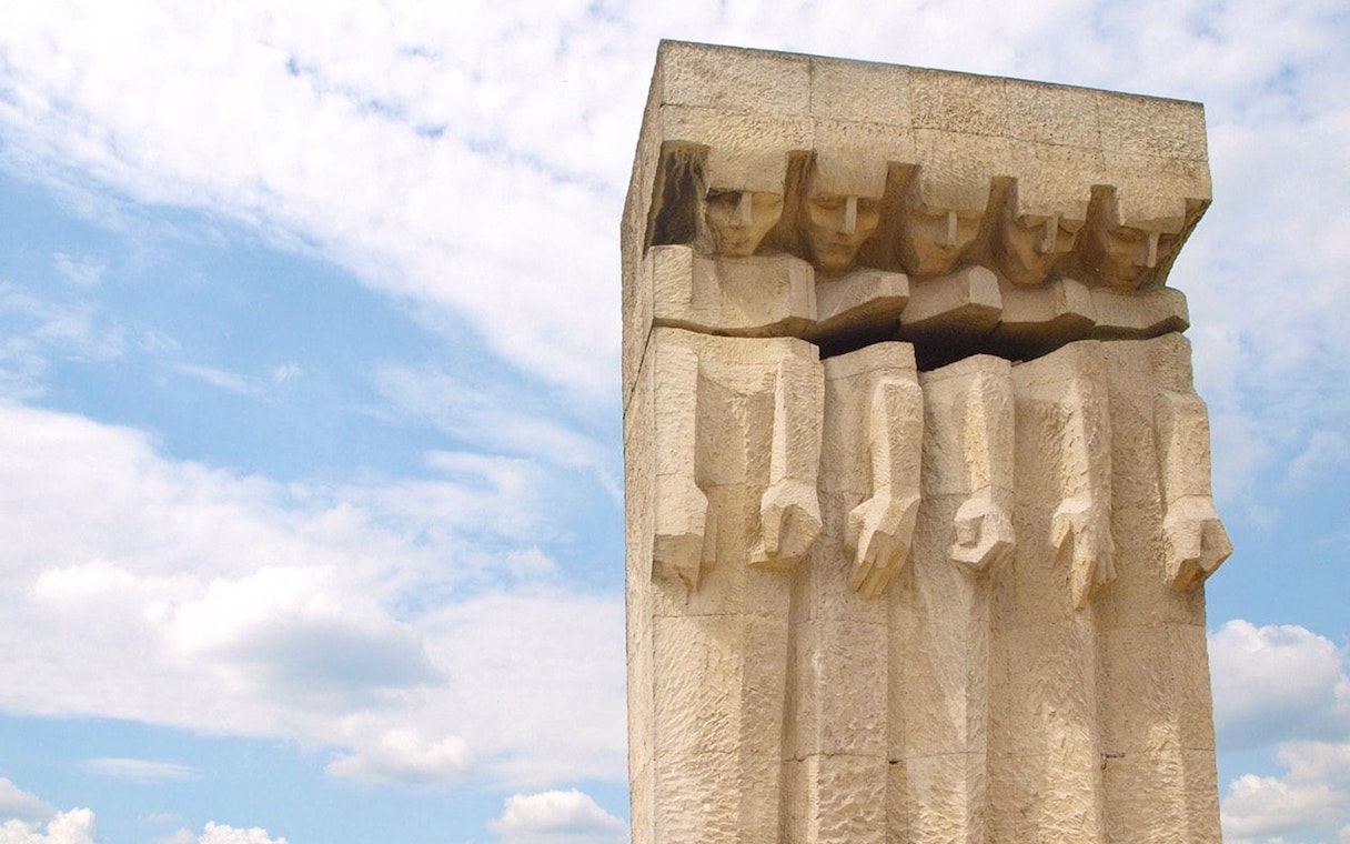Monument to the Victims of Fascism Plaszow in Krakow, stone figures against sky.