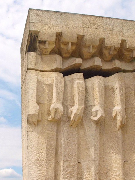Monument to the Victims of Fascism Plaszow in Krakow, stone figures against sky.