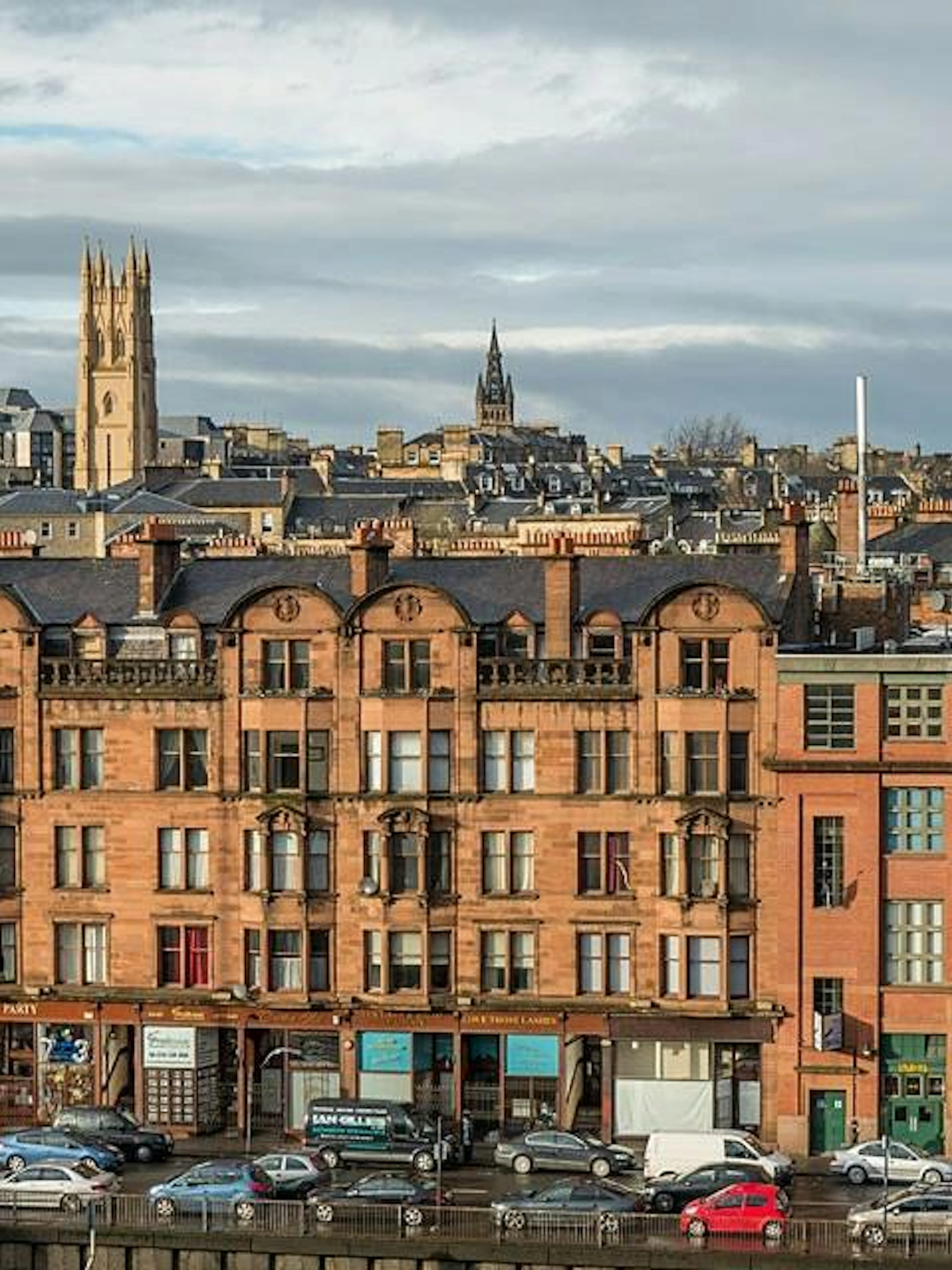 Historic buildings and skyline in Glasgow's West End, part of a self-guided city exploration game.