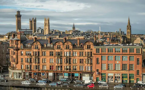 Historic buildings and skyline in Glasgow's West End, part of a self-guided city exploration game.