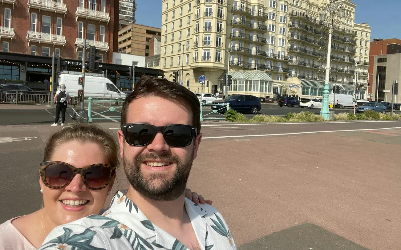 Couple enjoying a sunny day in front of historic Brighton buildings during a self-guided city exploration game.