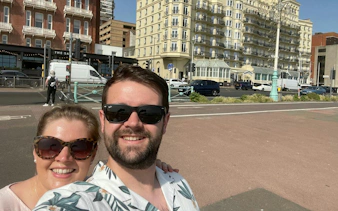Couple enjoying a sunny day in front of historic Brighton buildings during a self-guided city exploration game.