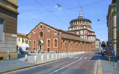 Santa Maria delle Grazie church in Milan, Italy, with tram tracks in foreground.