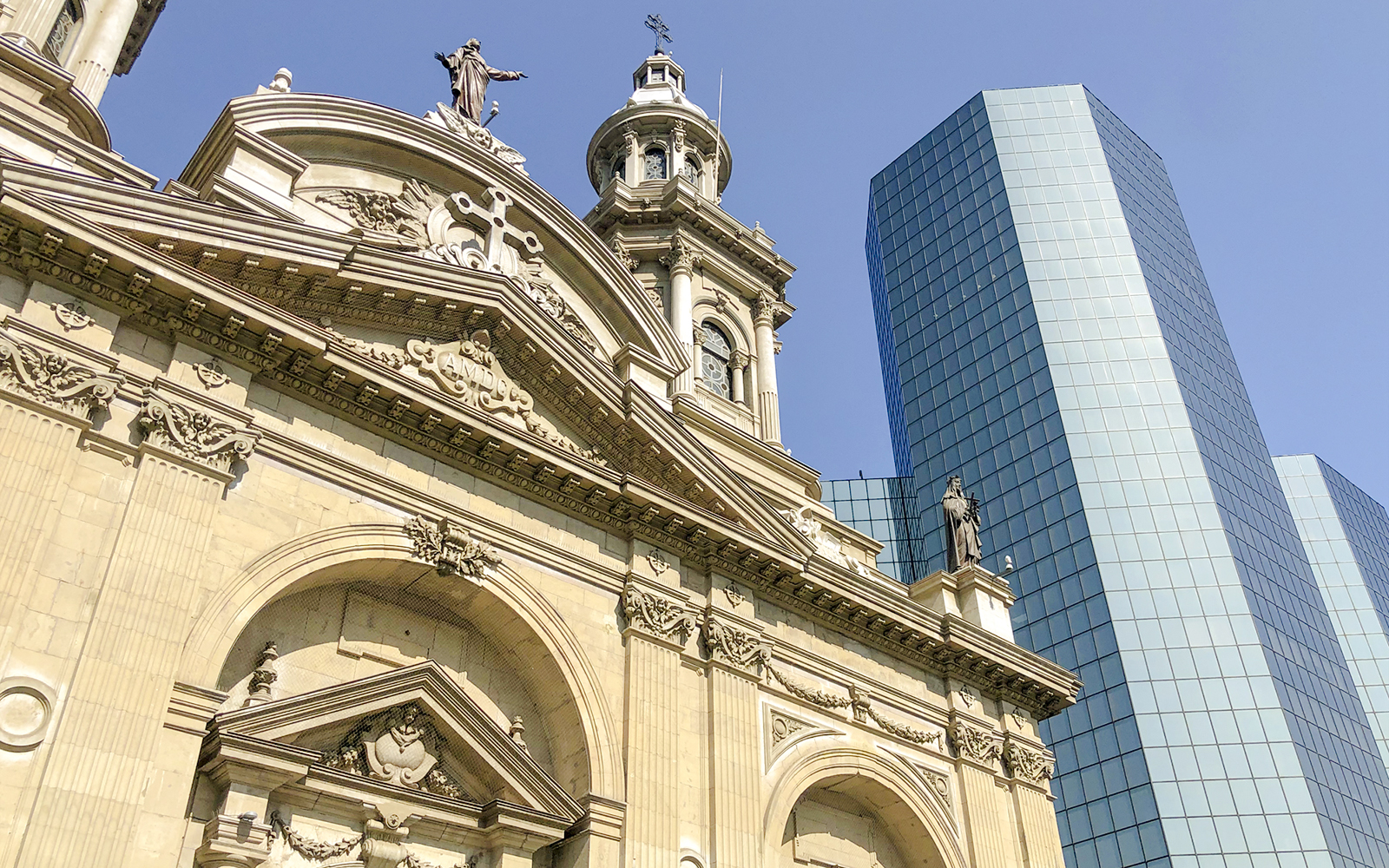 Santiago Cathedral facade with modern glass building in the background.