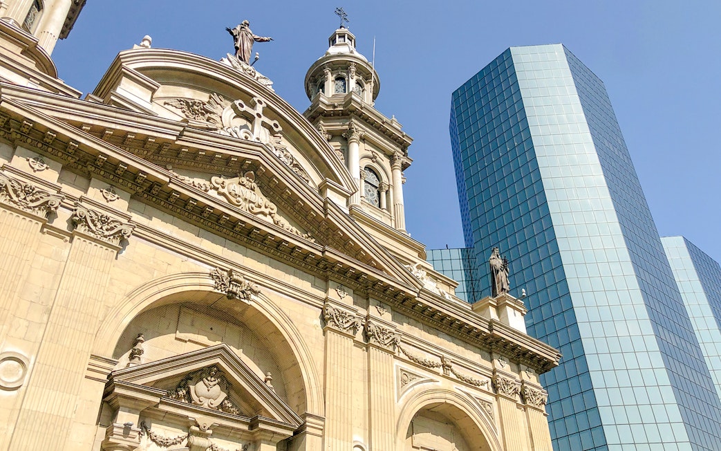 Santiago Cathedral facade with modern glass building in the background.