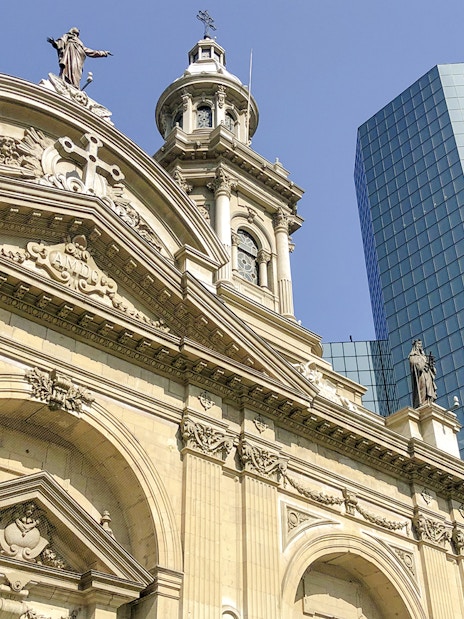 Santiago Cathedral facade with modern glass building in the background.