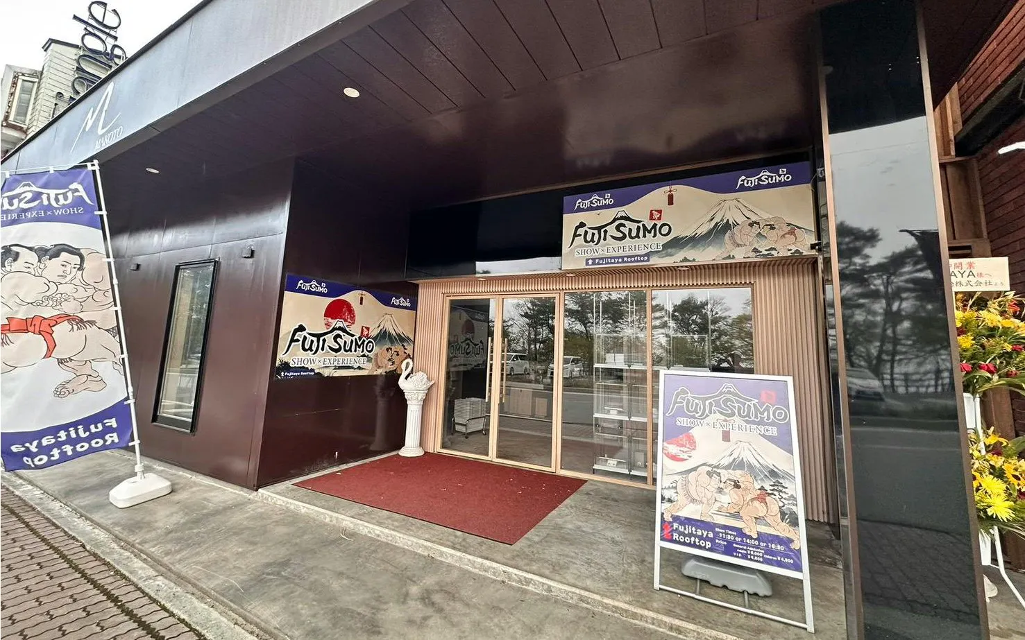 Entrance to Fuji Sumo Show and Experience in Yamanashi, featuring promotional banners.