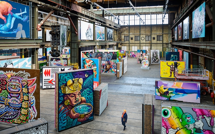 Straat Museum exhibits featuring vibrant street art in an industrial gallery setting.