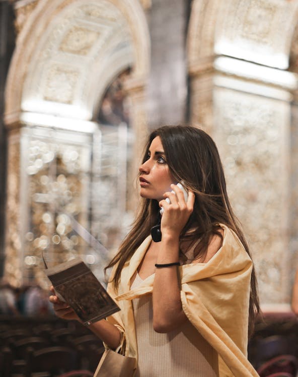 Visitor with audio guide exploring Sistine Chapel, Rome.