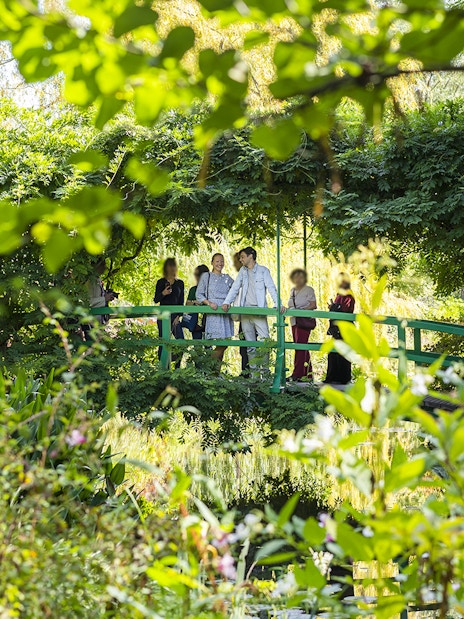 Visitors on Japanese bridge in Monet's Garden with guide.