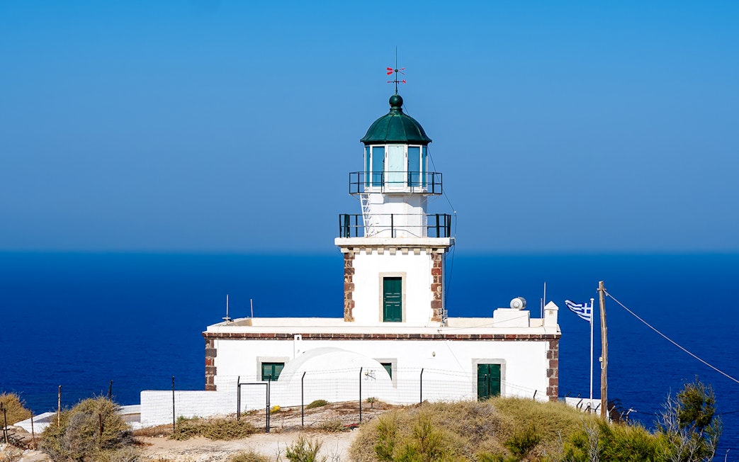 Akrotiri Lighthouse overlooking the Aegean Sea in Santorini, Greece.