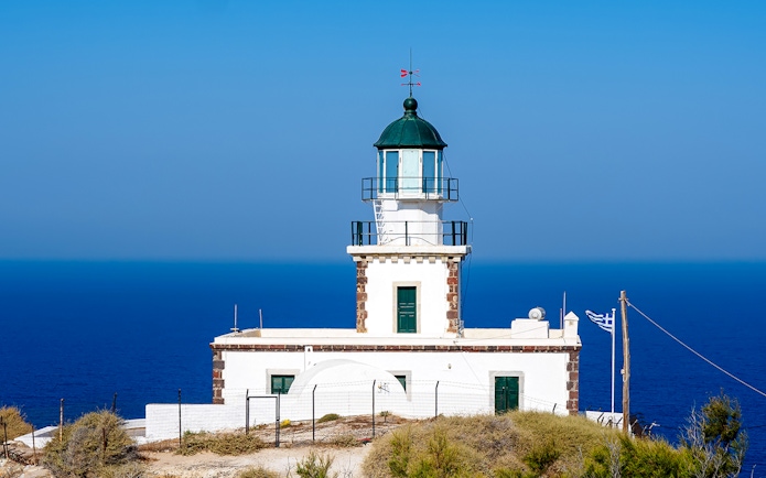 Akrotiri Lighthouse overlooking the Aegean Sea in Santorini, Greece.