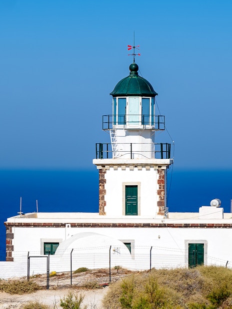 Akrotiri Lighthouse overlooking the Aegean Sea in Santorini, Greece.