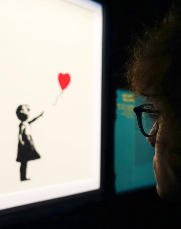 Visitor viewing Banksy's "Girl with Balloon" artwork.