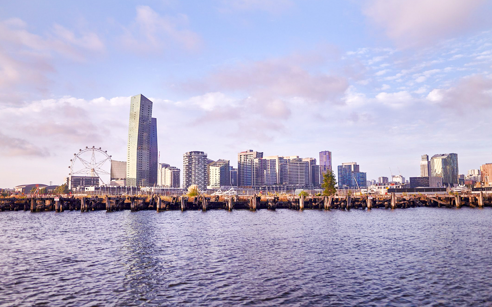 Melbourne skyline with Yarra River view, featuring city buildings and Ferris wheel.