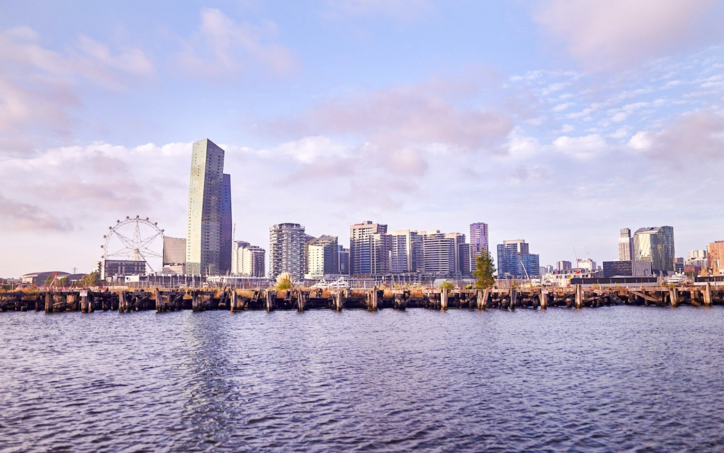 Melbourne skyline with Yarra River view, featuring city buildings and Ferris wheel.