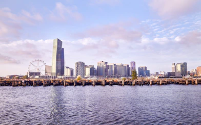 Melbourne skyline with Yarra River view, featuring city buildings and Ferris wheel.