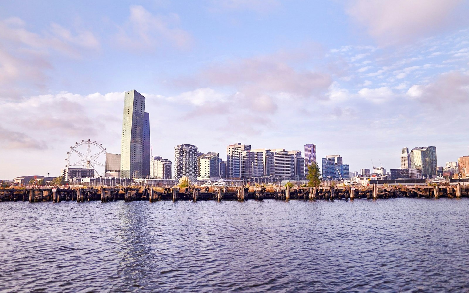 Melbourne skyline with Yarra River view, featuring city buildings and Ferris wheel.