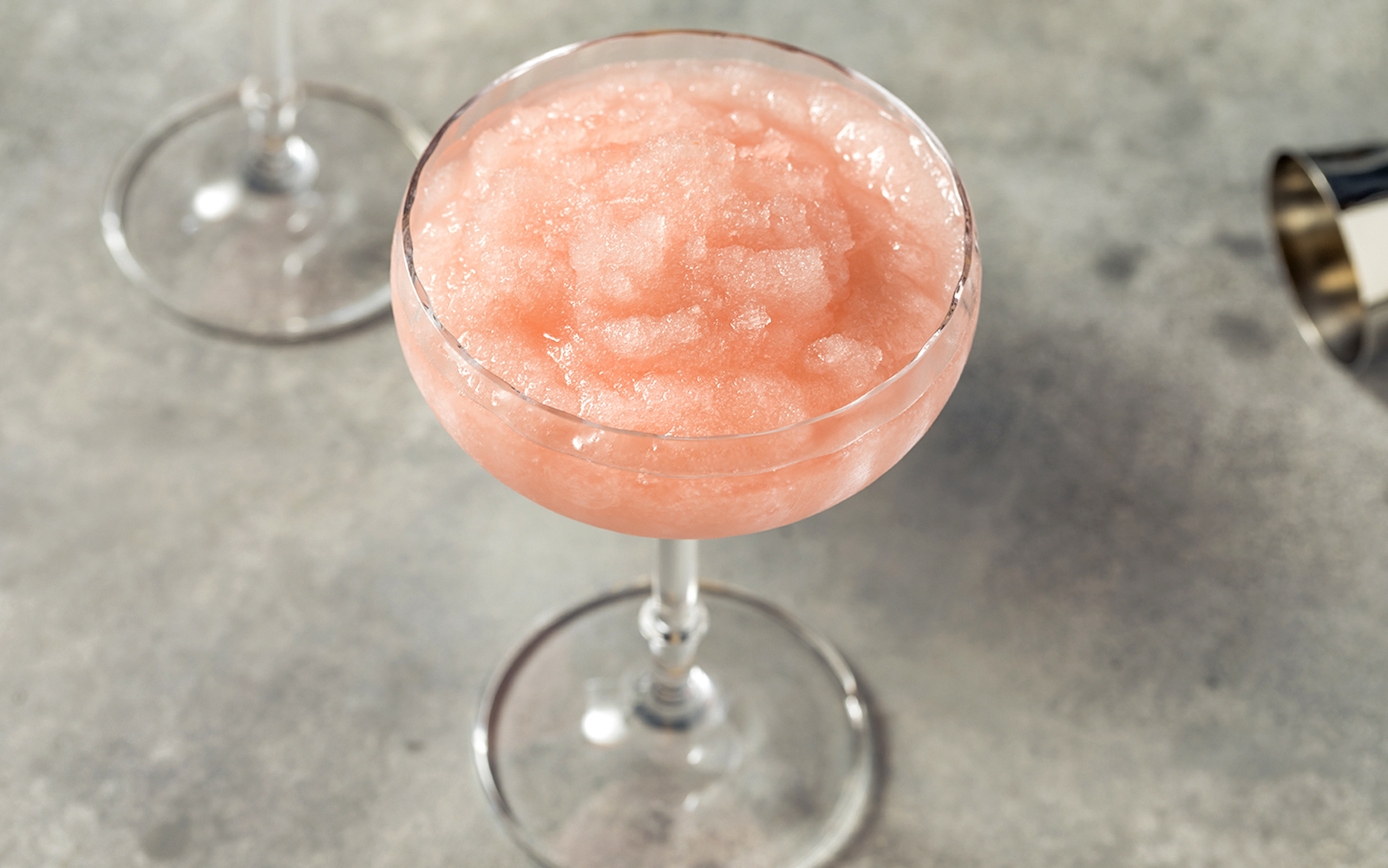 Homemade boozy frozen rosé slushie in a glass.