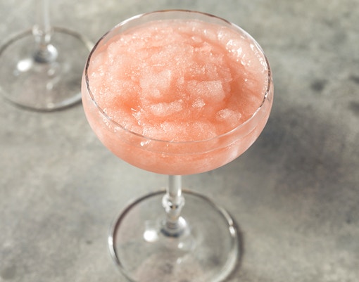 Homemade boozy frozen rosé slushie in a glass.