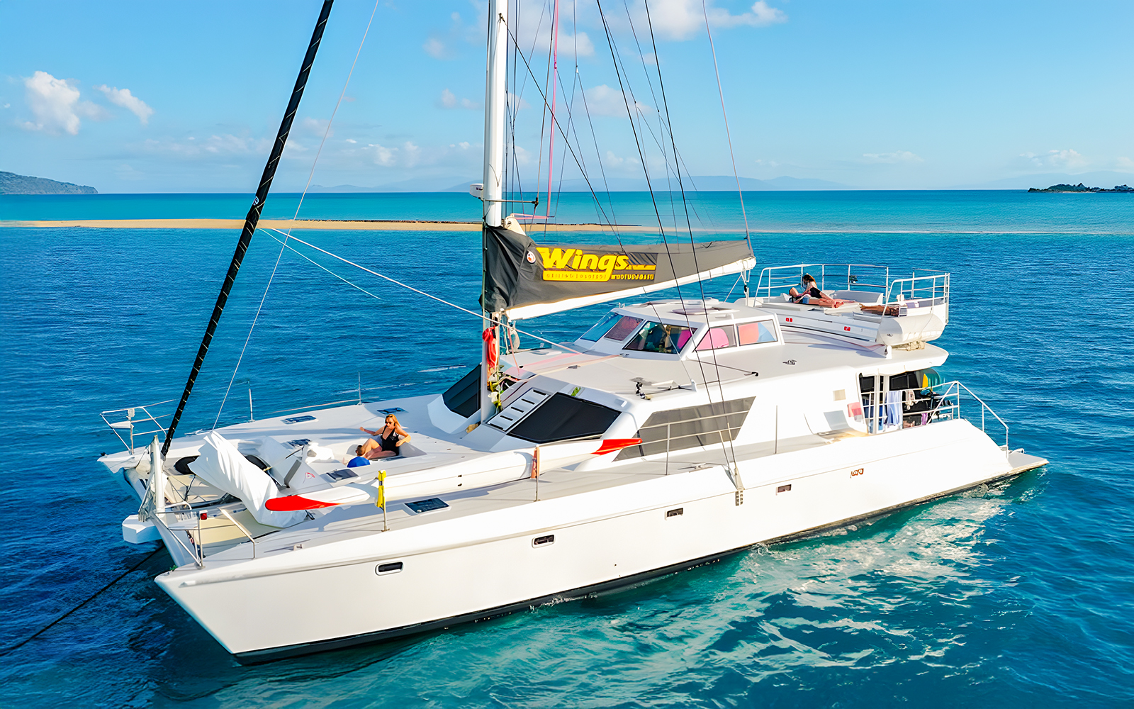 Tourists relaxing on a chartered catamaran in the Whitsundays.