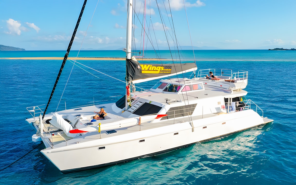Tourists relaxing on a chartered catamaran in the Whitsundays.