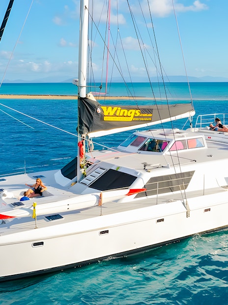 Tourists relaxing on a chartered catamaran in the Whitsundays.