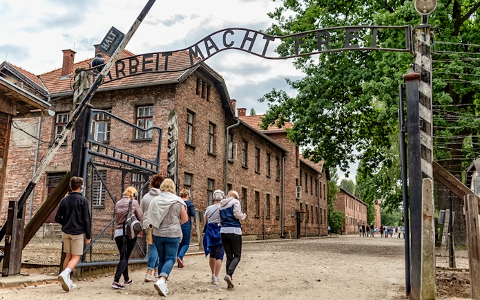 Visitors walking under the "Arbeit Macht Frei" gate at Auschwitz Concentration Camp.