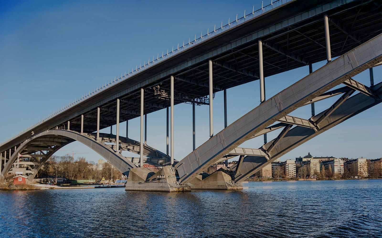 Västerbron Bridge spanning over water in Stockholm, with cityscape in the background.